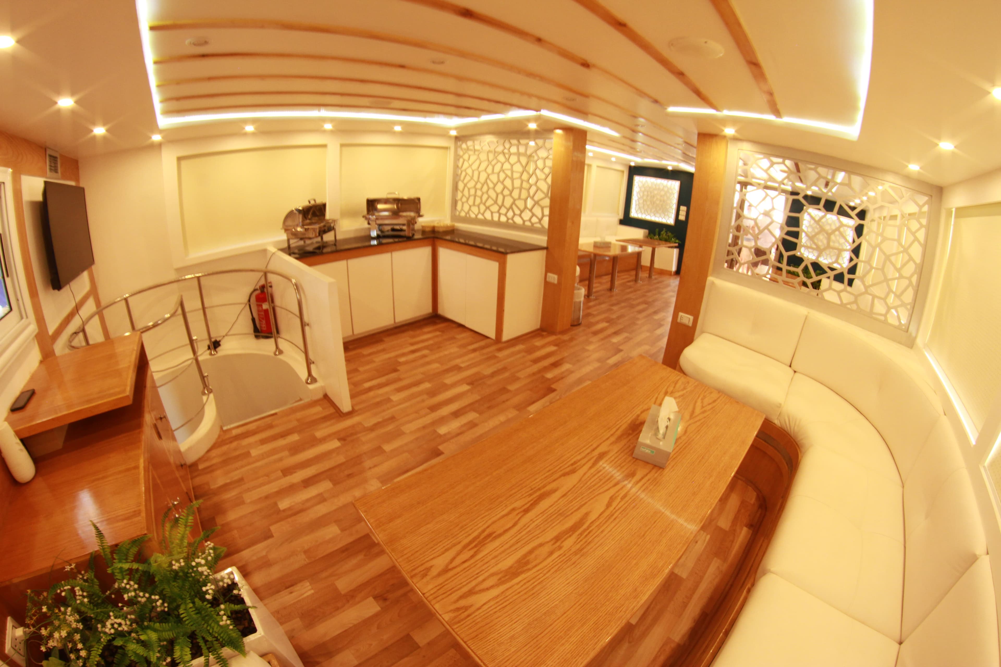 Indoor dining saloon with buffet chafing dishes and white leather seating