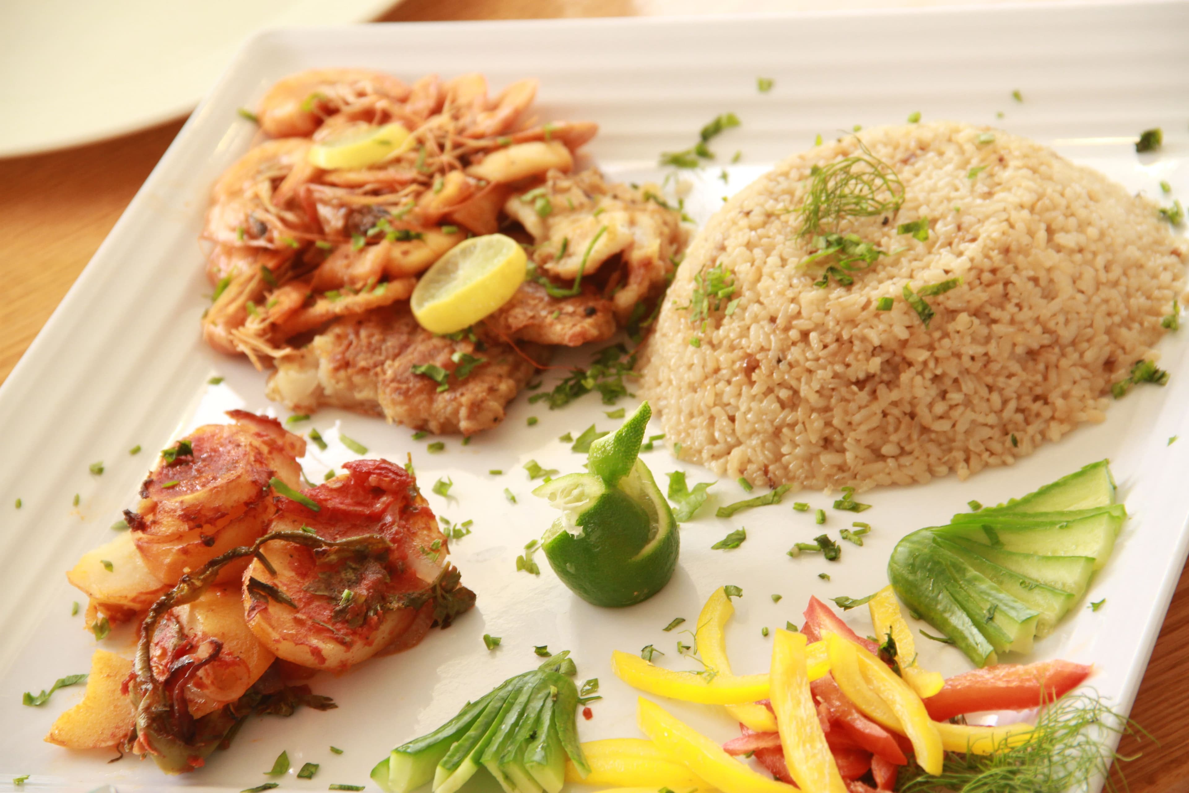 Plated lunch of grilled fish, shrimp, rice and fresh vegetables