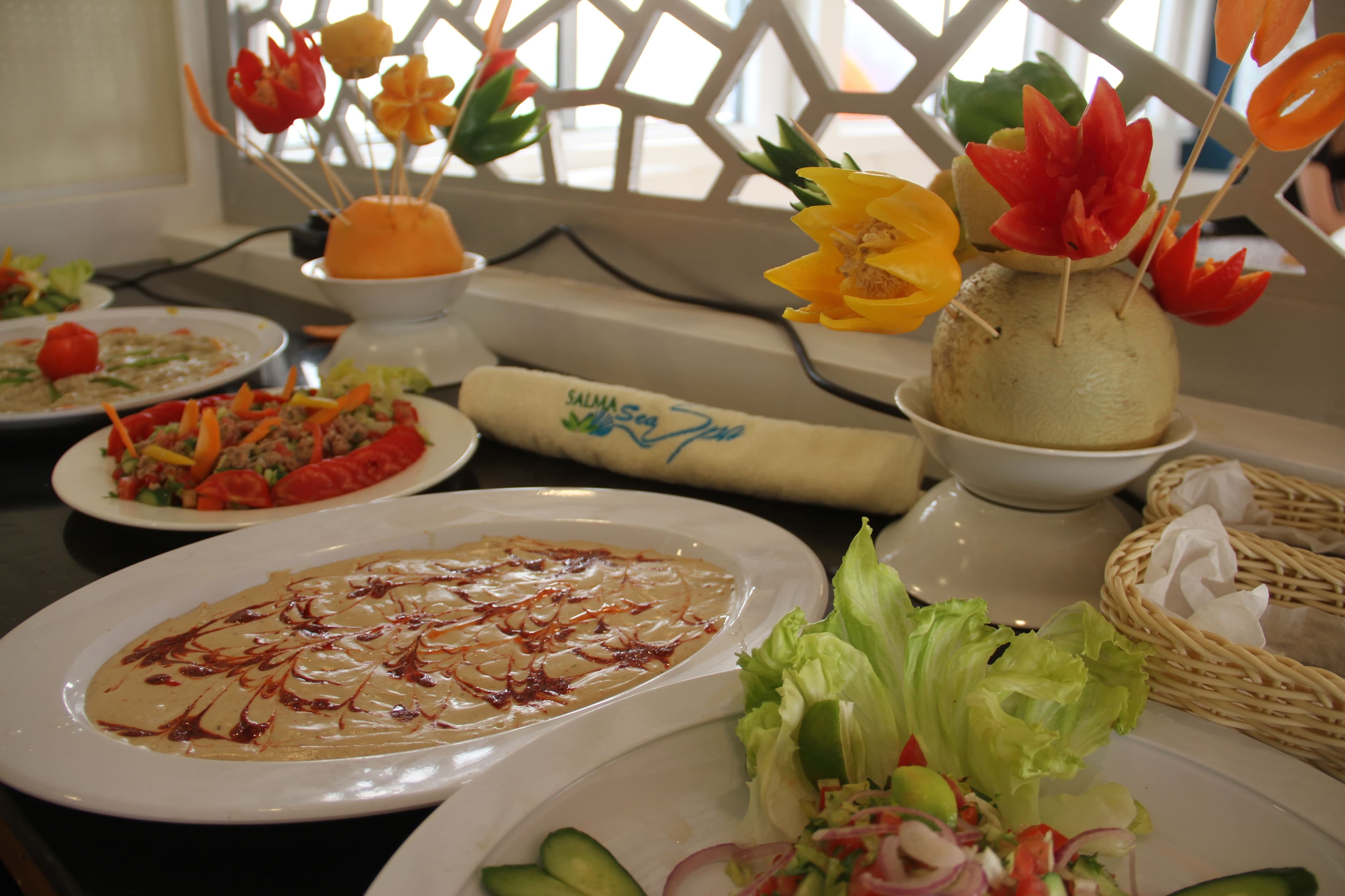 Buffet of salads and dips with carved-vegetable garnishes