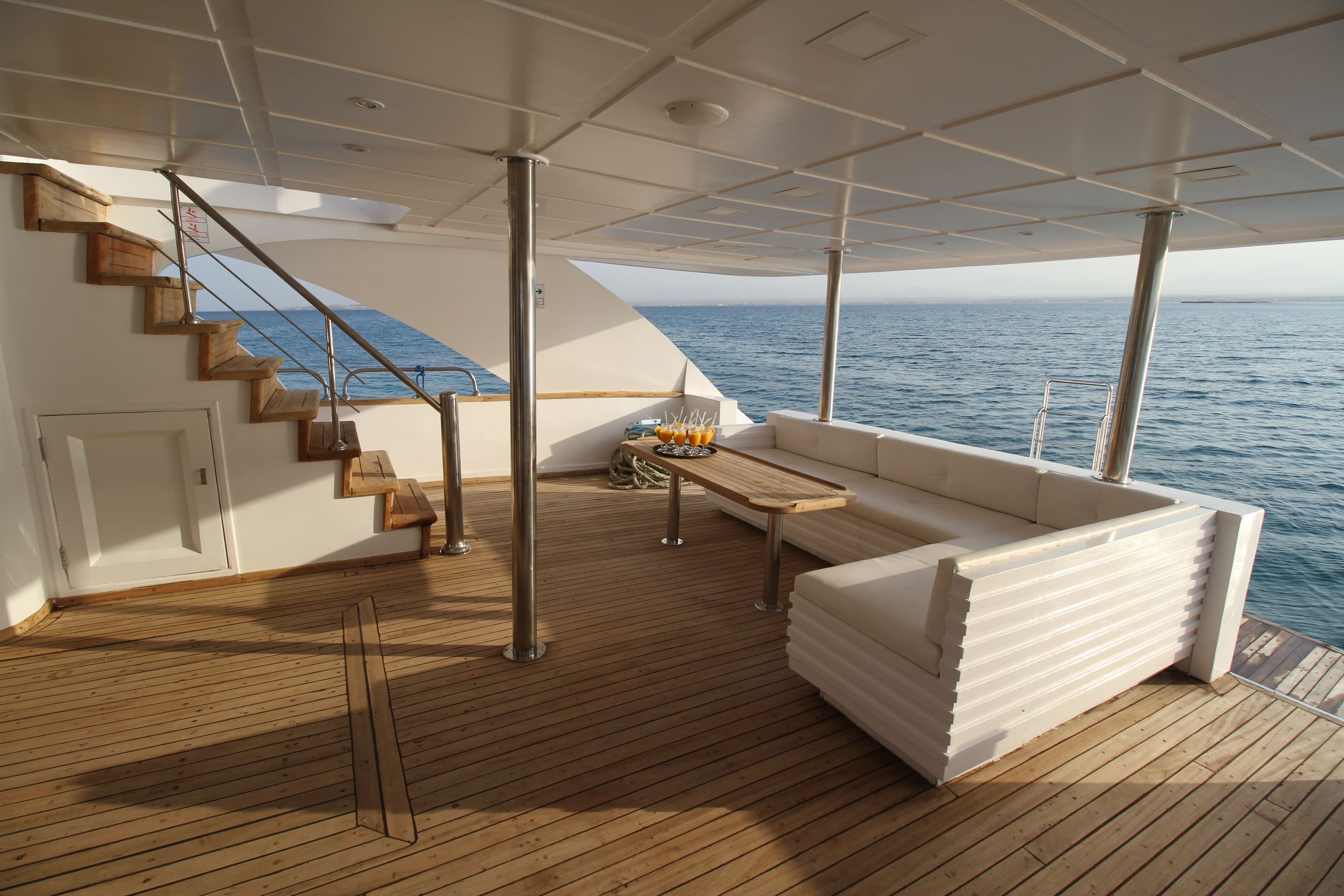 Shaded aft lounge deck with welcome juices on a teak table