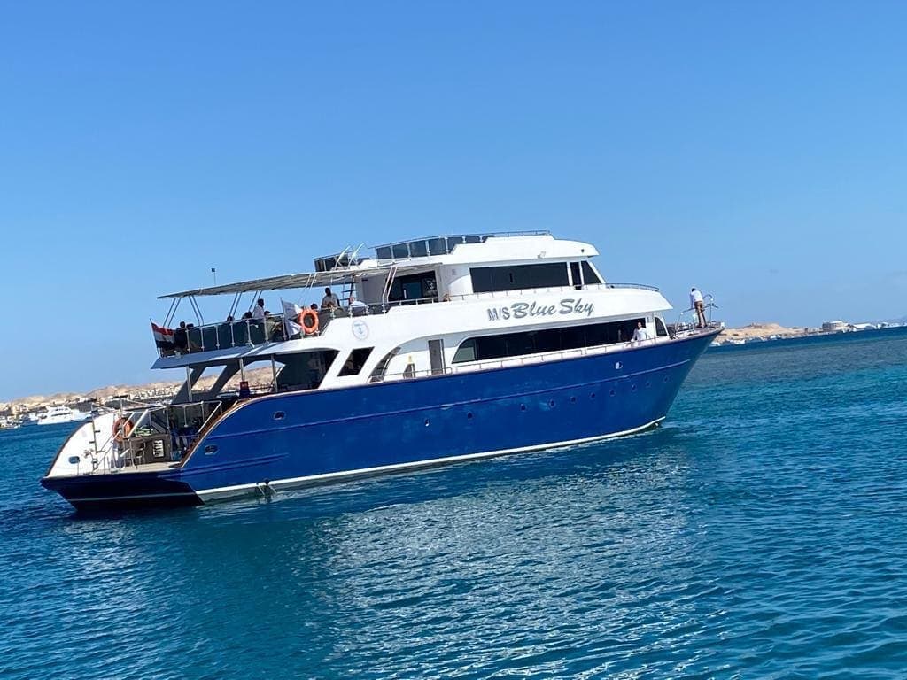 The M/S Blue Sky anchored off the Hurghada shoreline with guests on the upper deck