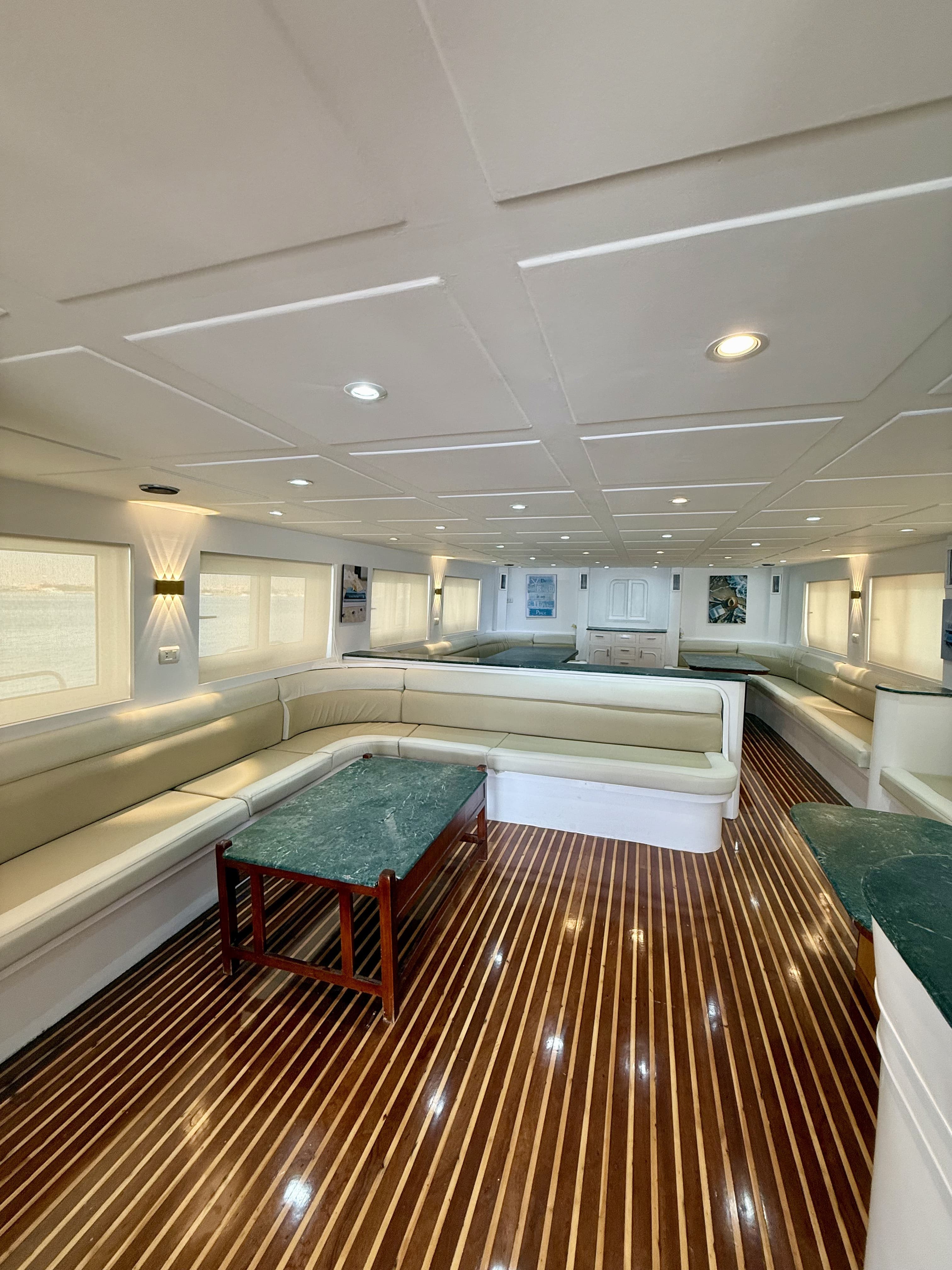 Air-conditioned indoor saloon with leather banquettes and green marble tables
